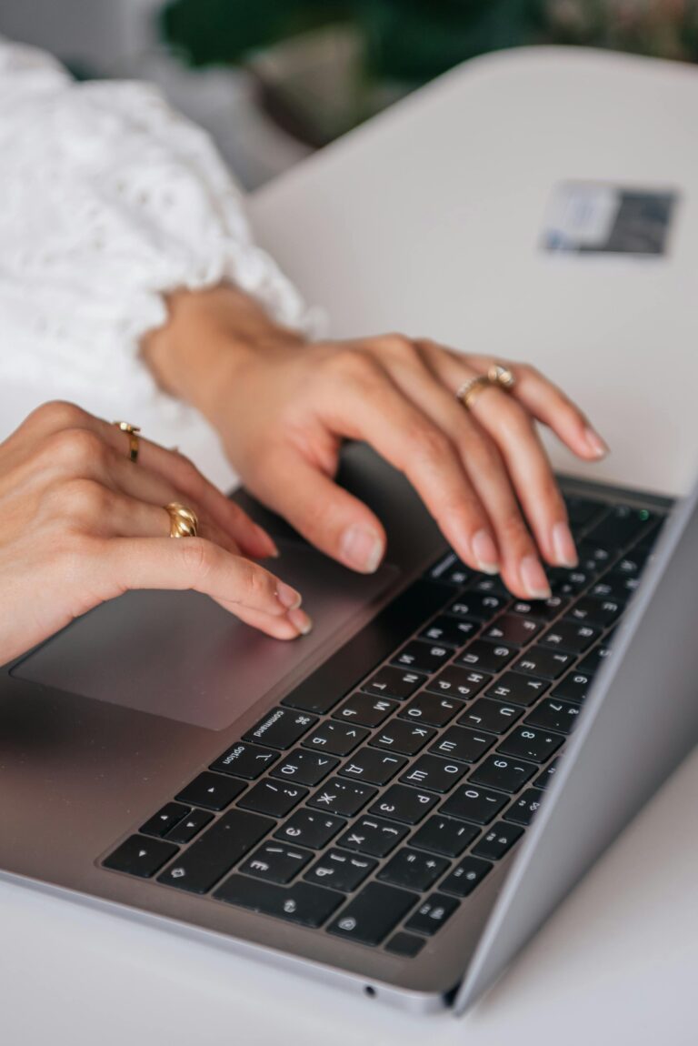 California Consumer Privacy Act person wearing a long sleeved white shirt typing on a gray laptop on top of a white desk
